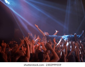 Crowd surfing, lighting and people at rock concert or music festival, neon lights and energy at live event. Dance, fun and group of excited fans in arena at rock show performance, audience stage dive - Powered by Shutterstock