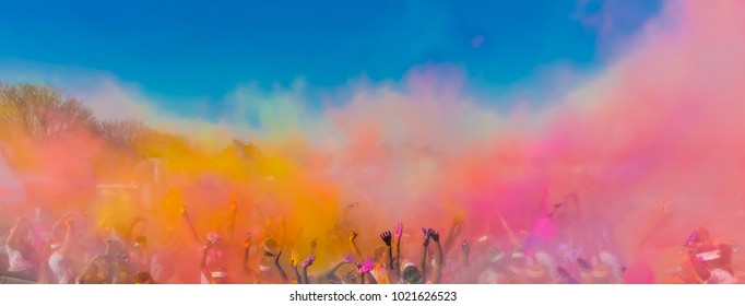 Crowd throwing bright colored powder paint in the air, Holi Festival Dahan
