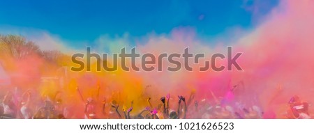 Crowd throwing bright colored powder paint in the air, Holi Festival Dahan