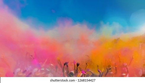 Crowd throwing bright coloured powder paint in the air, Holi Festival Dahan	