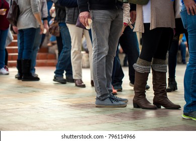 Crowd Of Unrecognizable People Wait In Line In A Urban Setting/queue Of People