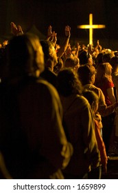 A Crowd Worships With Illuminated Cross