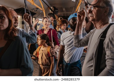 A crowded bus with diverse commuters standing and holding onto handrails during a busy ride.