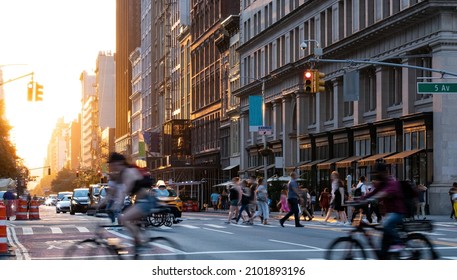 Crowded street scene with people, cars and bikes at the busy intersection of 23rd St and 5th Avenue in Manhattan New York City NYC