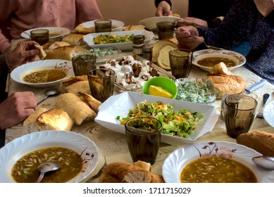 Crowded Turkish Muslim family eating delicious and miscellaneous food having dinner on a table together