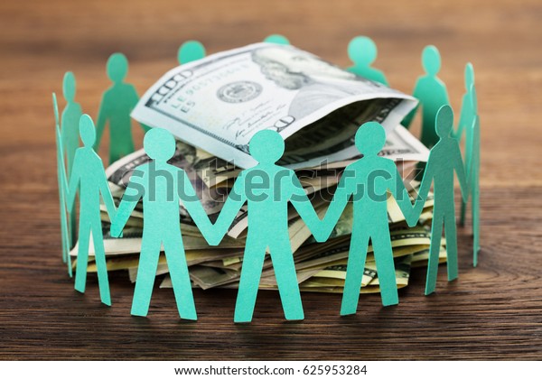 Crowdfunding Concept. Paper Cut Out Human\
Figures Around The Stack Of Hundred Dollar\
Bills