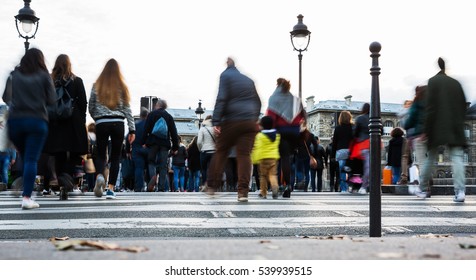 crowds of people in motion blur crossing a city street