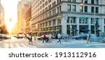 Crowds of people in motion walking across the busy intersection on 5th Avenue in Midtown Manhattan, New York City NYC