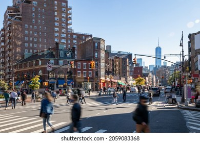 Crowds of people walking across a busy intersection on 7th Avenue in the West Village neighborhood of New York City NYC