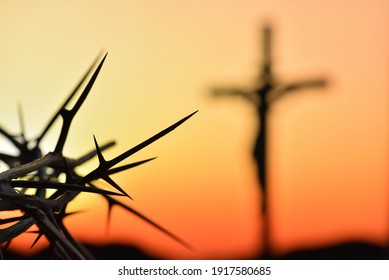 Crown Of Thorns Of Jesus Christ Against Silhouette Of Catholic Cross At Sunset Background