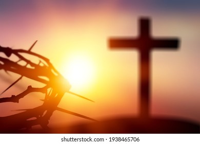 Crown Of Thorns Of Jesus Christ Against Wooden Catholic Cross At Sunset Background