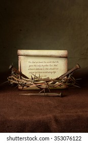 Crown of thorns and nails with John 3:16 verse over cloth