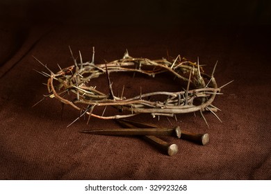 Crown of thorns and nails on cloth with dramatic lighting