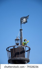 A crowsnest with a jolly roger flag and a happy parrot.