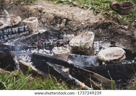 Crucible of clay mixed with sand. Liquid bronze is being heated inside to 1200°C in a small charcoal-fired hearth. Casting bronze jewelry technology. Viking age Metal Casting process. Bronze Age.