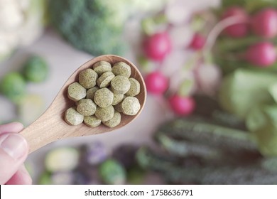 Cruciferous vegetables tablets in wooden spoon, dietary fiber prebiotic supplements for healthy gut