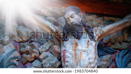Crucified Jesus Christ on holy cross. Ancient statue. Fragment.