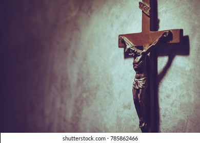 The Crucifix of Jesus Christ hanged on gray concrete wall background with copy space for your text, christian background