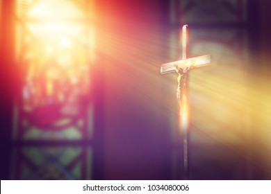 crucifix, jesus on the cross in church with ray of light from stained glass - Shutterstock ID 1034080006