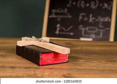 A Crucifix On A Book Against The Background Of A Written School Board