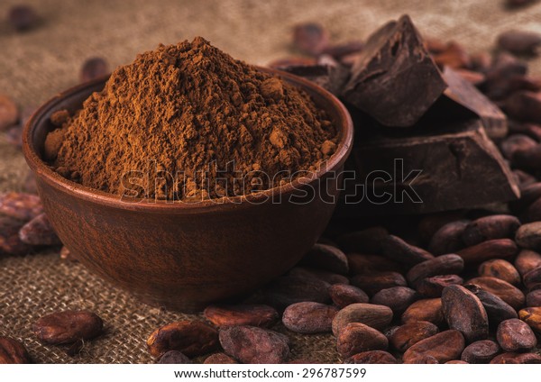 茶色の陶器鉢に生の暗いココアパウダー 皮に生のココア豆 袋詰めの生のチョコレート チョコレートと甘いものを作るための具 の写真素材 今すぐ編集