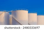 Crude Oil Industrial, White Storage Fuel Tanks Group against Blue Sky Background in Petroleum Refinery area