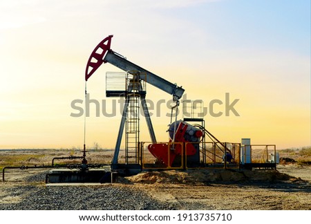 Crude oil pump jack at oilfield on sunset backround. Fossil crude output and fuels oil production. Oil drill rig and drilling derrick. Global crude oil Prices, energy, petroleum demand Stock fotó © 