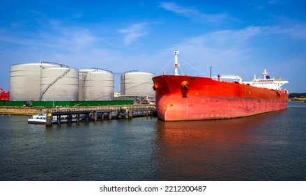 Crude oil tanker docked at a oil storage silo terminal in the port.