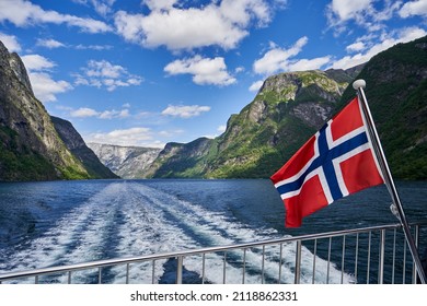 Cruise in Nærøyfjord, Norway. View of the fjord from the boat with Norwegian flag.