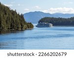 Cruise ship in between pine tree forest islands of the Inside Passage between Prince Rupert and Port Hardy, Vancouver Island, BC, Canada.