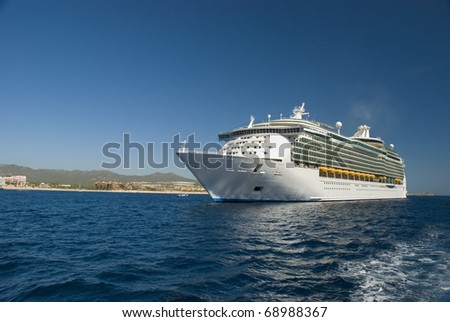 A Cruise ship docked in Cabo San Lucas, Mexico. The beach and condominiums are in the background.