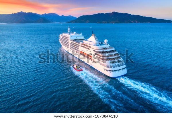 Cruise ship at harbor. Aerial view of beautiful
large white ship at sunset. Colorful landscape with boats in marina
bay, sea, colorful sky. Top view from drone of yacht. Luxury
cruise. Floating liner