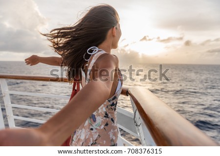 Cruise ship vacation travel woman enjoying freedom. Holiday tourist with open arms in front of boat feeling carefree in the tropical wind .