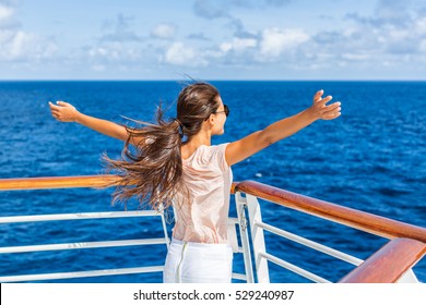 Cruise ship vacation woman enjoying travel vacation at sea. Free carefree happy girl looking at ocean with open arms in freedom pose.