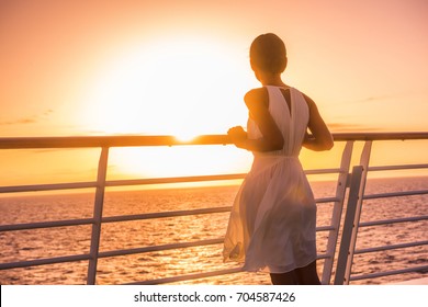 Cruise ship vacation woman travel watching sunset at sea ocean view. Elegant lady in white dress relaxing on deck balcony, luxury holiday destination.