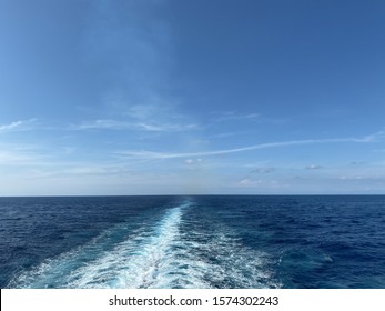 Cruise ship wake on a beautiful sunny day with white clouds and blue seas on the Atlantic Ocean.