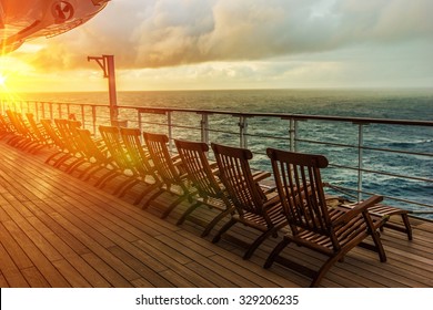 Cruise Ship Wooden Deck Chairs. Cruise Ship Main Deck at Sunset.