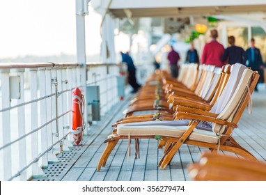 Cruise Ship Wooden Deck Chairs and Some Senior Tourists. 