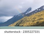 Cruising end of the world - Cockburn Channel and Glacier alley. Snowy peak with sun and rainbow.