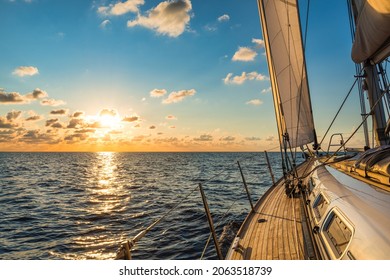 Cruising sailboat sailing in the Mediterranean Sea at sunset