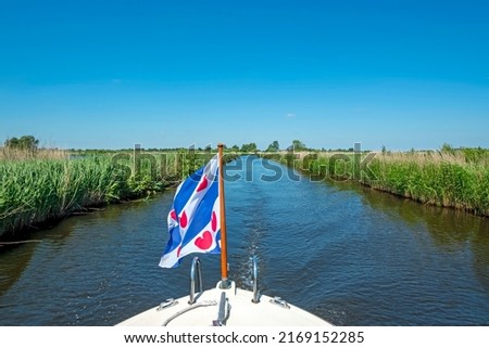 Cruising through National Park Alde Feanen in Friesland the Netherlands with the frisian flag