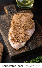 Crumbed uncooked chicken breasts ingredient, on wooden table