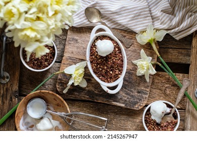 Crumble with apple and chocolate. Narcissus, ice cream, wood background, top view