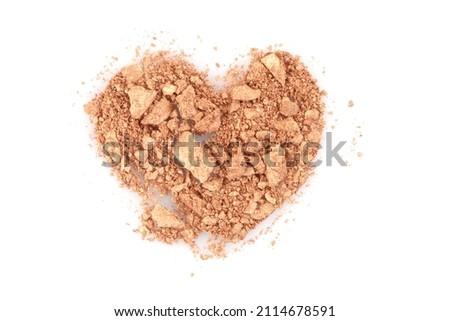Crumble and crushe pearl beige bronze heart shape  eyeshadows, powder. Broken cosmetics on white background. 