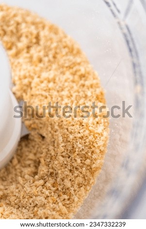 Crumbling stale bread in a food processor to make bread crumbs.