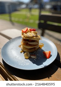 Crumpet Breakfast Stack With Bananas And Strawberries At Outdoor Coffee Shop