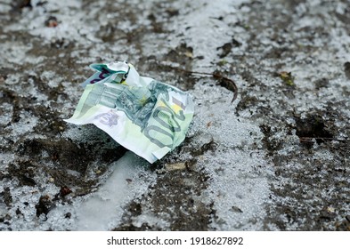 A Crumpled ˆ 100 Bill Lies On The Frozen Ground. Lost Money. Winter, Outdoors. No People