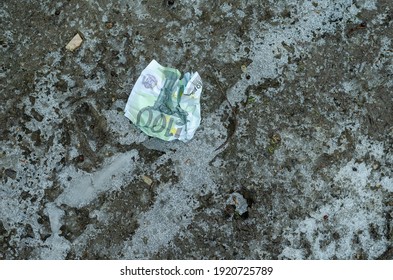 A Crumpled ˆ 100 Bill Lies On The Frozen Ground. Lost Money. Winter, Outdoors. No People