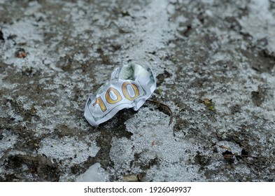 A Crumpled $ 100 Bill Lies On The Frozen Ground. Lost Money. Winter, Outdoors. No People