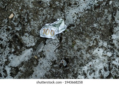 A Crumpled $ 100 Bill Lies On The Frozen Ground. Lost Money. Winter, Outdoors. No People